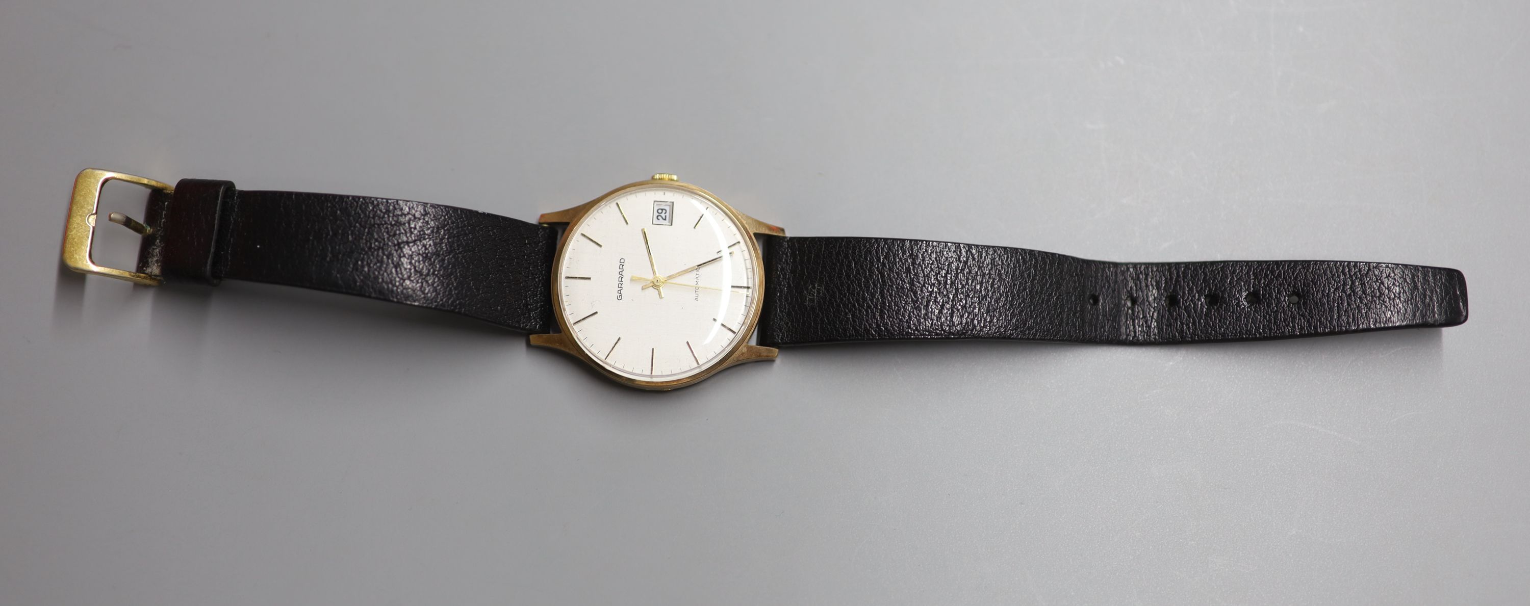 A gentlemans 1980s yellow metal automatic wrist watch, retailed by Garrard, with case back inscription,